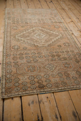 Vintage distressed Oushak runner displaying muted sandalwood, beige, and coffee brown geometric patterns.