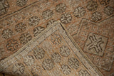 Distressed Oushak runner's textured pile and woven back with sandalwood, ivory, beige tones.