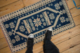 A vintage distressed Oushak rug in cobalt blue and ivory, shown on a floor to provide scale.