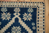 Cobalt blue and ivory geometric motifs and detailed border of a distressed Oushak rug.