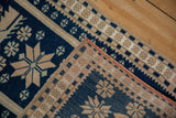 Folded corner of a vintage Oushak rug showing the blue pile and hand-knotted reverse.