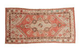 Distressed Oushak runner in faded red and antique ivory, with medallion, floral motifs, and vine border.