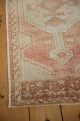 Corner view of the distressed Oushak runner's copper brown border and floral motifs.