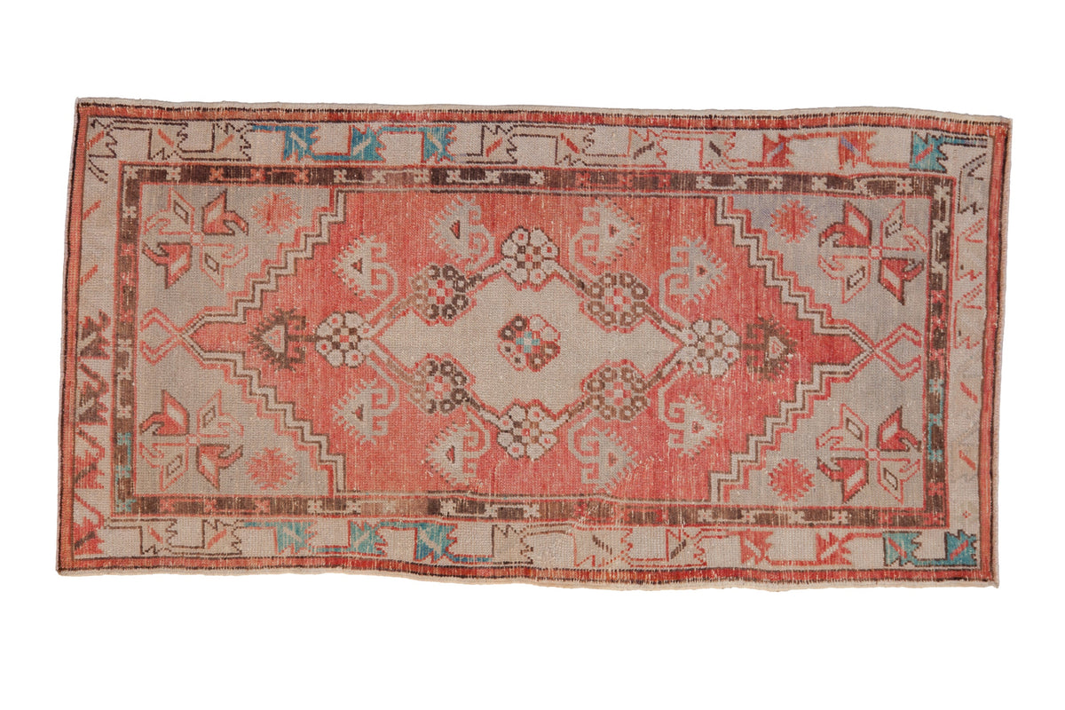 Distressed Oushak rug runner with a diamond medallion in dusty rose, silver, and pops of turquoise.