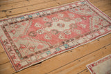 The geometric pattern and abrashed, dusty rose texture of a vintage distressed Oushak runner.