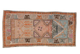 Vintage distressed Oushak runner, prayer motif, geometric patterns, and rainbow colors.