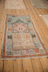 Distressed vintage Oushak runner with germinating plant and geometric hook patterns, rainbow palette.
