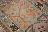 Distressed Oushak rug section with germinating plant motif, dusty blush, and geometric patterns.