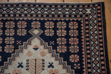 Close view of the geometric corner spandrel and floral motifs in navy blue and dusty rose.