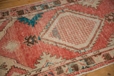 Low-pile texture of the checkered diamond medallion on a distressed vintage Oushak rug.