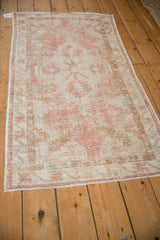 Angled view of a vintage Oushak runner showing its decorative, distressed texture and soft colors.
