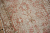 Mostly even wear across knot heads on a distressed Oushak rug in dusty rose and silver.