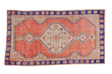 Vintage distressed Oushak rug with a stepped hexagonal medallion in dusty rose, ivory, and cobalt blue.