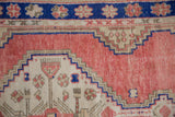 Geometric floral bouquets and stepped motifs in cobalt blue, ivory, and distressed dusty rose.
