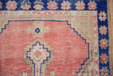Cobalt blue floral border meets the stepped geometric pattern on a distressed, dusty rose rug.