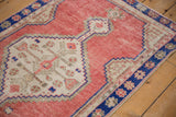 Cobalt blue floral border and stepped medallion on a distressed dusty rose vintage Oushak rug.