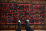 Close view of the hand-knotted texture and stylized guls on a vintage Persian Kurdish rug.