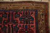 Stylized guls within the camel brown border and short fringe of a vintage Persian Kurdish rug.