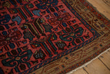 Corner view of a vintage Kurdish Hamadan rug showing its intricate camel border and dense wool pile.