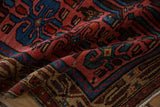 Time-softened tones of raspberry red, sapphire blue, and gold on the low, hand-knotted pile of a vintage rug.