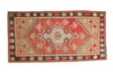 Vintage distressed Oushak rug with a brick red medallion, beige field, and dark charcoal floral border.