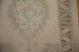 Evenly worn hand-knotted pile of a vintage Oushak rug showing its copper brown border and stepped medallion.