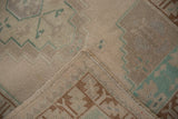 A folded corner reveals the hand-knotted foundation and secured selvage of a vintage Turkish rug.