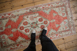 Vintage Turkish Oushak runner with a red medallion shown underfoot for scale and context.