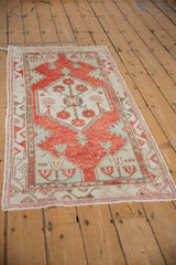 High-angle view of the distressed Oushak runner's geometric motifs in cherry red and seafoam green.