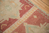 Faded raspberry red, ivory, and pale tangerine hook and latch border detail on a distressed Kars rug.