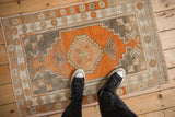 A vintage Turkish Oushak rug with terracotta and silver tones, seen from overhead to show its scale.