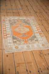 Angled view of a vintage Oushak rug showing its stepped geometric design and distressed texture.
