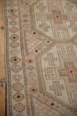 Vintage Distressed Oushak rug showing pale rose, ivory, powder blue geometric and floral patterns.
