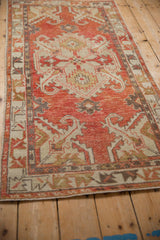 Angled view of a distressed Oushak runner highlighting its decorative wear and brick red medallion.