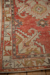 Low pile and hand-knotted detail of a distressed Oushak rug's corner and border.