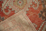 Folded corner showing the hand-knotted weave and distressed red pile of a vintage Oushak runner.