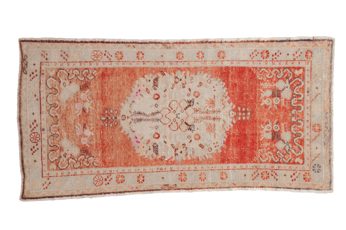 Vintage Oushak runner with an oversized ivory medallion on a distressed, abrashed brick red field.
