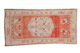 Vintage Oushak runner with an oversized ivory medallion on a distressed, abrashed brick red field.