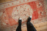 A view from above showing the distressed texture of the Oushak runner's central medallion.