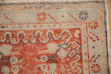 Close-up of the corner spandrel and floral motifs on a distressed vintage Oushak rug.
