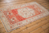 Distressed Oushak runner from an angle, with a faded brick red and ivory medallion design.
