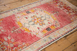 Distressed vintage Oushak runner side with intact selvage, faded red, gold, and blossom patterns.