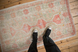 Overhead view showing the scale and distressed, low-pile texture of a vintage Oushak rug.