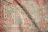 Softly worn texture of a hand-knotted Oushak rug in pale terracotta and muted seafoam green.