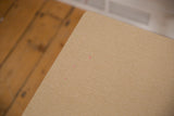 Light wood grain texture on the vintage end table corner with small pink marks showing wear.