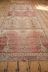 Distressed Oushak runner fragment pile showing faded raspberry, cream, and silver tree motifs.