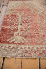 Detailed view of distressed Oushak runner's even pile, geometric pattern, and secured end.
