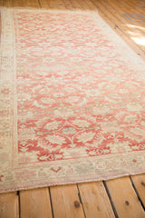 Distressed Turkish Oushak rug features faded raspberry and ivory floral patterns, even wear.
