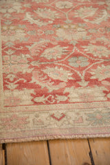 Faded raspberry and ivory tones on distressed vintage Turkish Oushak rug with bound ends.