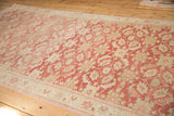 Evenly worn field of scrolled leaves and floral motifs in faded raspberry, cream, beige.